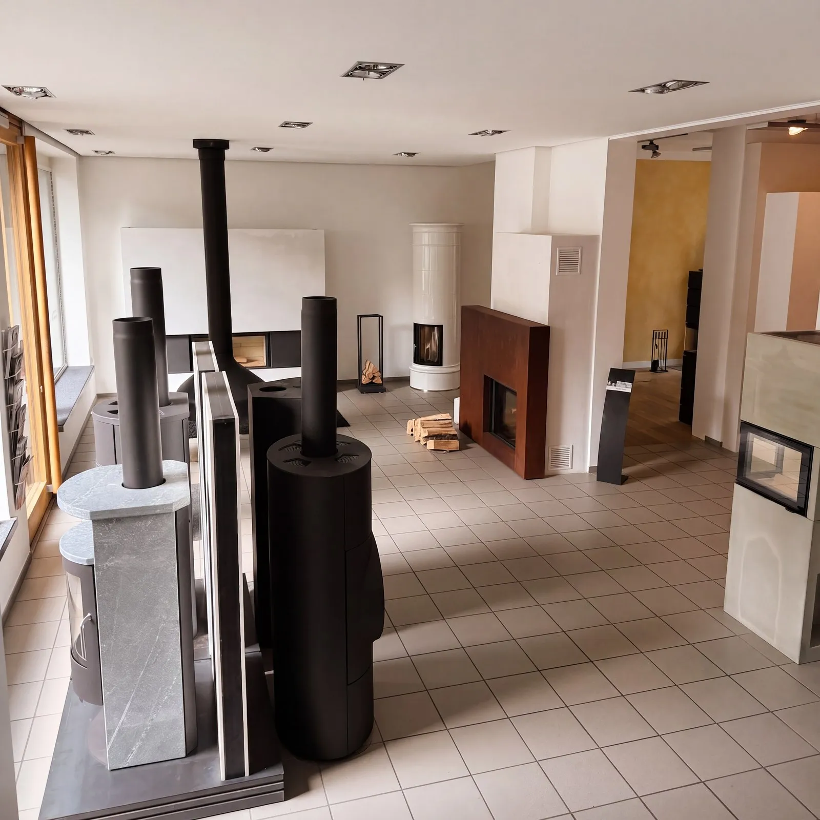 Blick durch die Ausstellung von Ofen Baule mit mehreren Kaminanlagen und Kaminöfen