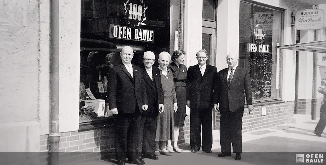 Sechs Mitglieder der Familie und Belegschaft Baule vor dem Schaufenster am Neustädter Markt, aufgenommen zum hundertjährigen Bestehen